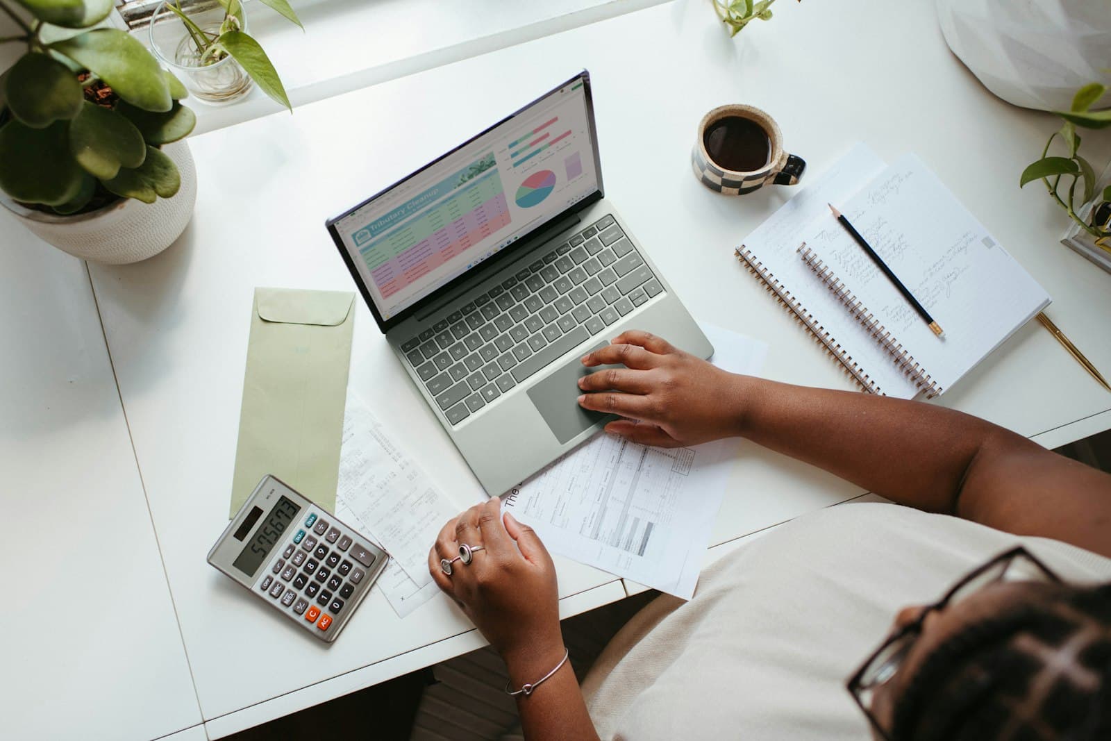Persona revisando planillas y cuentas de su negocio en el escritorio
